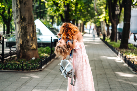 Woman hugs her daughter, holding her in her armsの写真素材