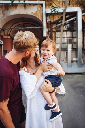Happy parents playing with little son outdoorの写真素材