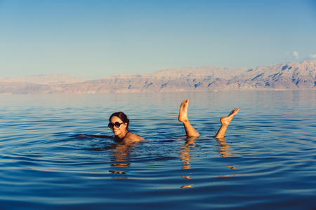 Girl is relaxing and swimming in the waterの写真素材