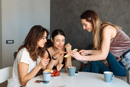 three woman friends breakfast in the kitchenの写真素材