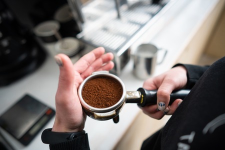Barista holding portafilter with ground coffeeの写真素材