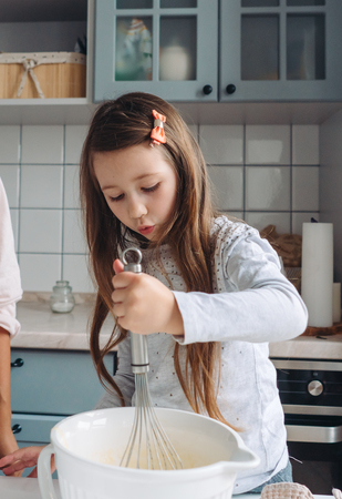 little girl cooks in the kitchenの写真素材