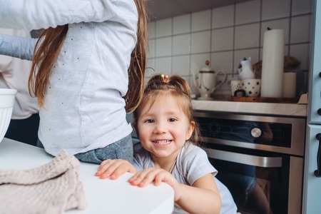two little girls cook in the kitchenの写真素材