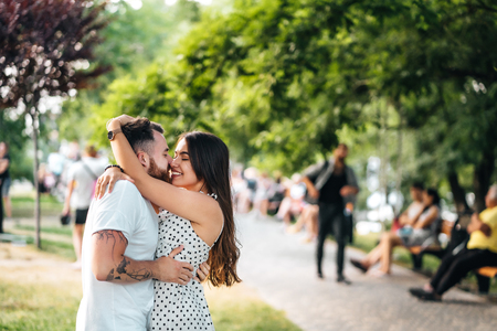 Handsome guy and young girl hugging in the park.の写真素材