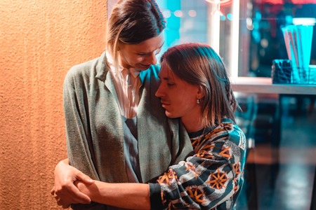 Young couple at the bar, guy hugs his girlfriendの写真素材