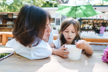 Mother and daughter are sitting in a cafeの写真素材