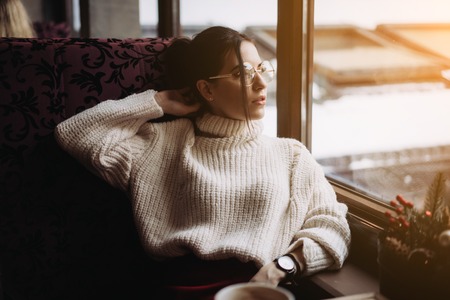 Girl enjoying flavor of coffee while relaxing at coffee shopの写真素材