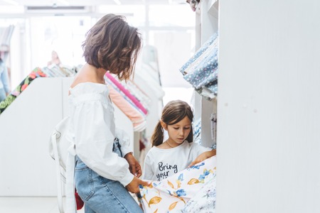 Mom and daughter in the fabric store choose fabricの写真素材