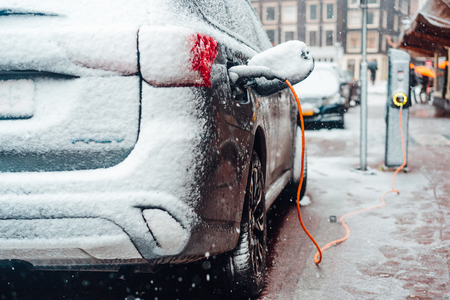 Electric car plug charging in the winterの写真素材