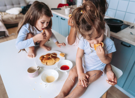 Mom and two daughters eat pancakesの写真素材