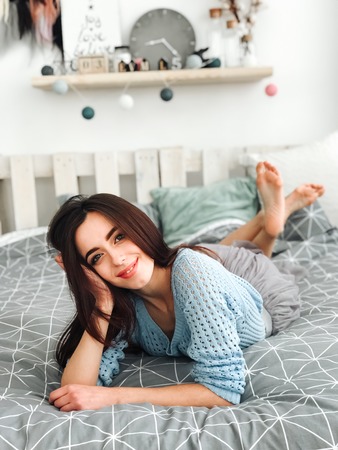 attractive brunette girl in lingerie lying on bedの写真素材