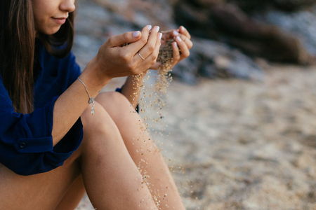 Detail of sand running through open hands.の写真素材