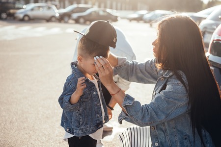Mom corrects the little sons cap.の写真素材
