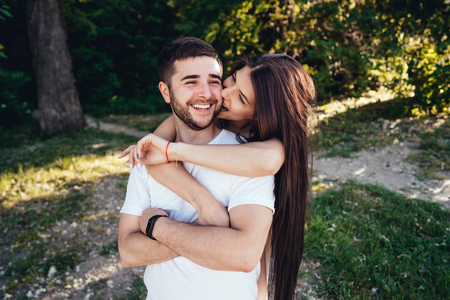 Young couple walking and kissing in summer park.の写真素材