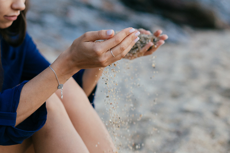 Detail of sand running through open hands.の写真素材