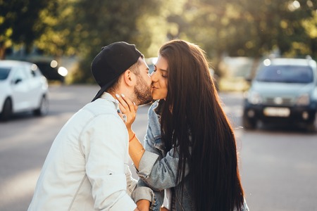 Young, loving parents kiss in the parking near the supermarket.の写真素材