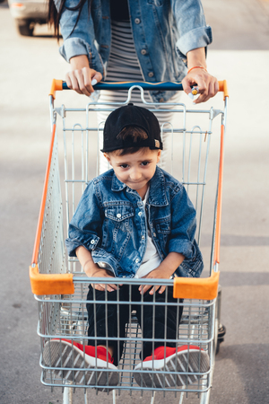 Small boy, Mom carries in a cart near the supermarket.の写真素材