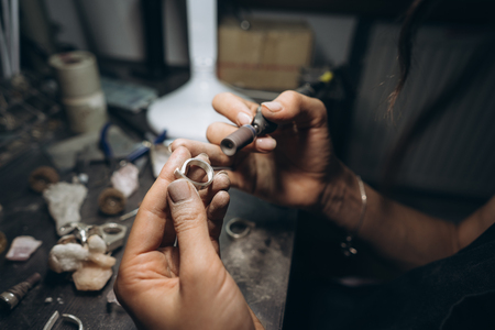 girl master processes the metal plate in the home workshopの写真素材