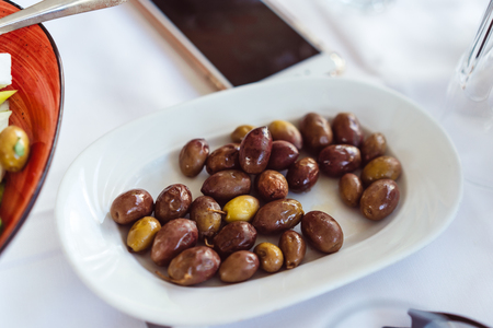 On the plate lie large, pickled Greek olives.の写真素材