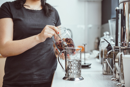 Pour dry tea leaves into the glass container of the tea press makerの写真素材