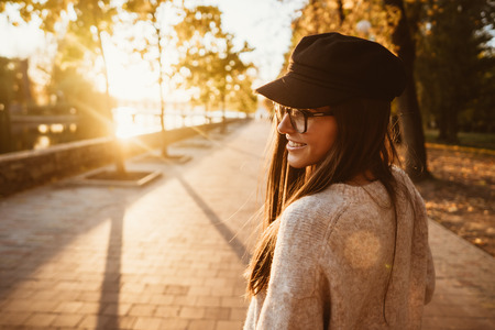 Attractive, young brunette with long hair walking autumn park.の写真素材