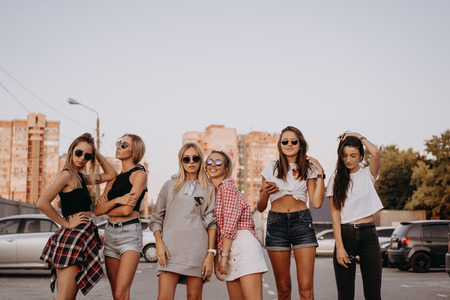 Six young women have fun at the car park.の写真素材