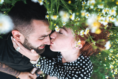 Young couple lies on the field with daisies.の写真素材