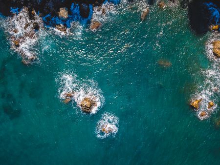Drone top view of a sea cliff and a beach