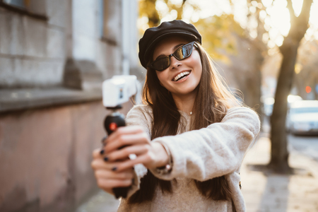 Cute, young female blogger posing on camera.の写真素材