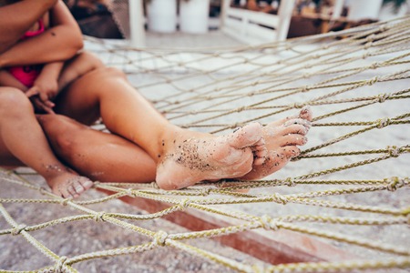 happy mother with her daughter lying in a hammockの写真素材