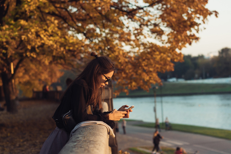 Attractive woman using smartphone outdoors in the parkの写真素材