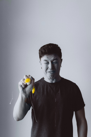 Guy crushes a chicken egg in his hand