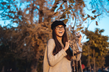 Beautiful young girl with handbag posing on cameraの写真素材