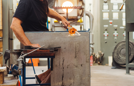 A Glass Blower Shaping Molten Glass into a Piece of Artの写真素材