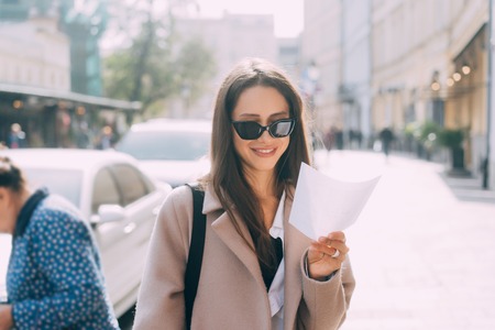 Young stylish woman posing at the street and looking at camera.の写真素材