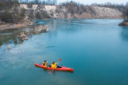 two athletic man floats on a red boat in riverの写真素材