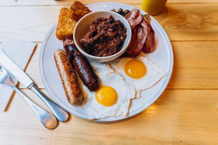 Breakfast with bacon, sausage, egg, beans and mushroomsの写真素材