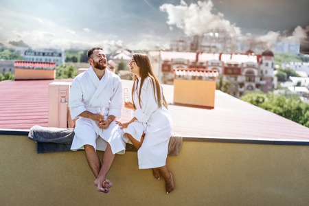 flirting couple with sparkling wine on a roofの写真素材