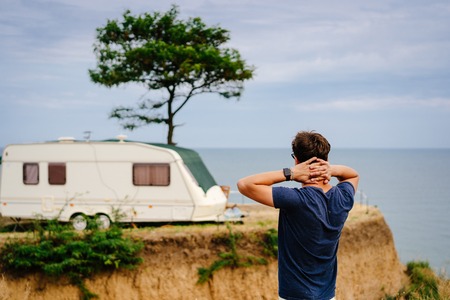 Handsome, young guy posing on a wild seashoreの写真素材