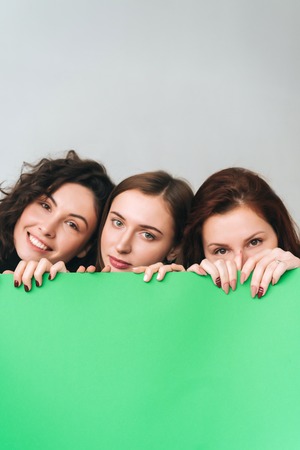 Three beautiful young girls posing for the cameraの写真素材