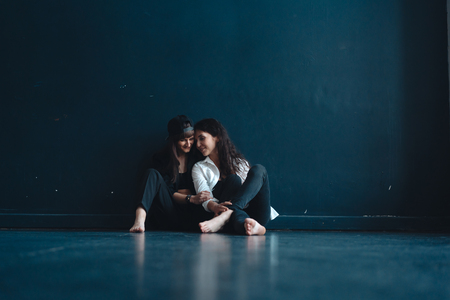 beautiful girls sit by the wall and poseの写真素材