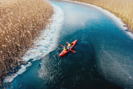 two athletic man floats on a red boat in riverの写真素材