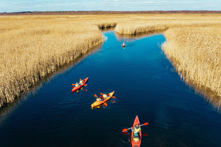 Group of people in kayaks among reeds on the autumn river.の写真素材