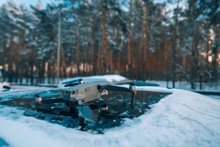 quadrocopter standing on the roof of a snow-covered carの写真素材