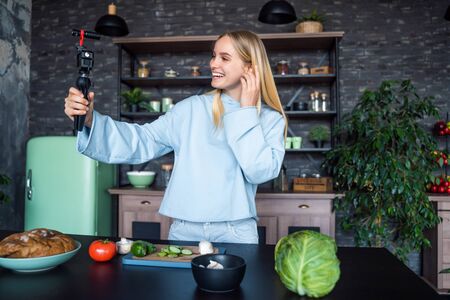 Beautiful young girl posing in the kitchenの写真素材