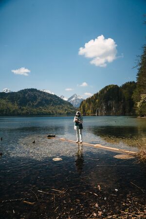 Young beautiful girl feeds a duck by the lakeの写真素材