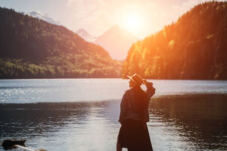 The girl in the dress and hat of the lake in the mountains