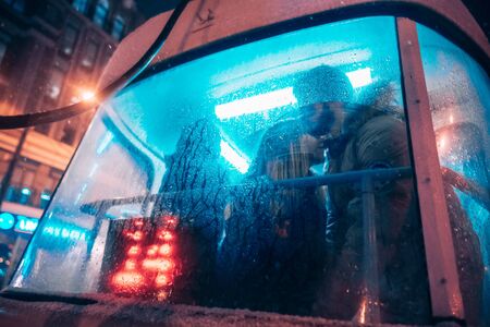 The guy and the girl kiss on the tram behind the misted glassの写真素材