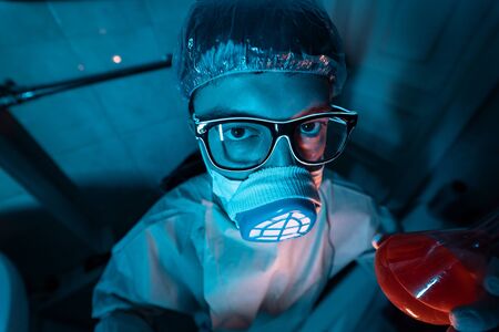 Young male researcher carrying out scientific experiment.