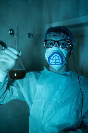 Young male researcher carrying out scientific experiment.